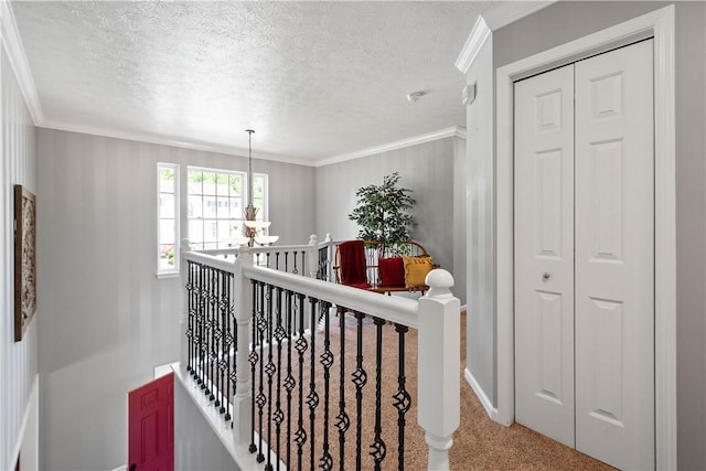 5121 Forest Ridge Dr, South Fayette, PA 15057 - hall featuring a textured ceiling, ornamental molding, baseboards, carpet, and an upstairs landing