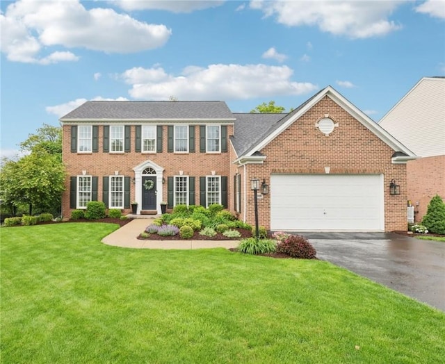 319 Buffalo Ridge Rd, Peters Twp, PA 15317 - colonial house featuring asphalt driveway, a front yard, brick siding, and a garage
