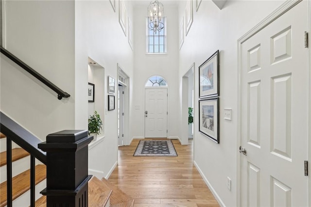 319 Buffalo Ridge Rd, Peters Twp, PA 15317 - foyer with stairway, a chandelier, light wood-type flooring, a high ceiling, and baseboards