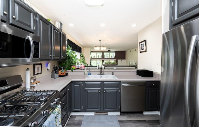 1099 Riverside Dr Unit H, Bridgewater, PA 15009 - kitchen featuring appliances with stainless steel finishes, a sink, a chandelier, light countertops, and dark wood finished floors