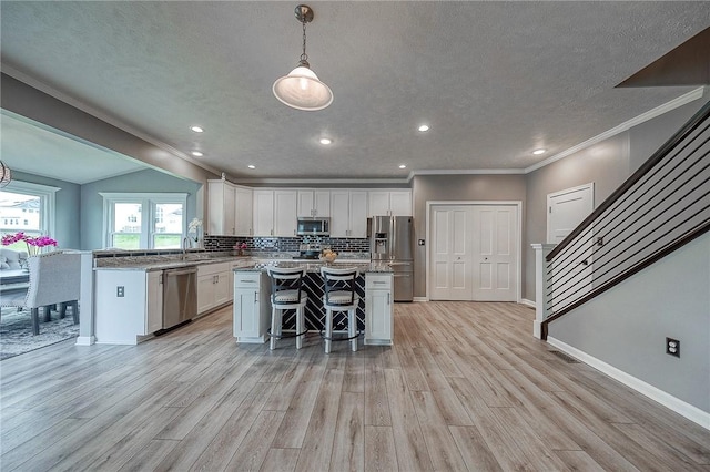8 Pony Ct, Findlay Twp, PA 15126 - kitchen with stainless steel appliances, white cabinetry, light wood finished floors, a kitchen island, and a kitchen breakfast bar