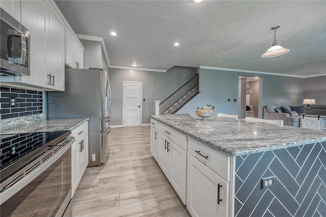 8 Pony Ct, Findlay Twp, PA 15126 - kitchen featuring appliances with stainless steel finishes, ornamental molding, a center island, white cabinetry, and light stone counters