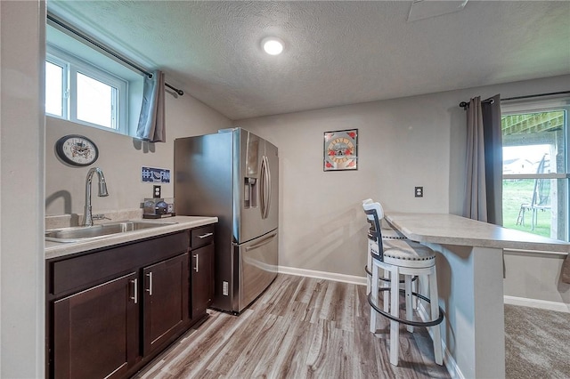 8 Pony Ct, Findlay Twp, PA 15126 - kitchen featuring a sink, stainless steel refrigerator with ice dispenser, a kitchen bar, dark brown cabinetry, and a peninsula