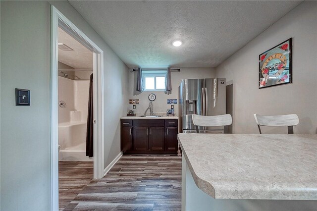 8 Pony Ct, Findlay Twp, PA 15126 - kitchen with stainless steel fridge, dark wood finished floors, a textured ceiling, dark brown cabinetry, and light countertops
