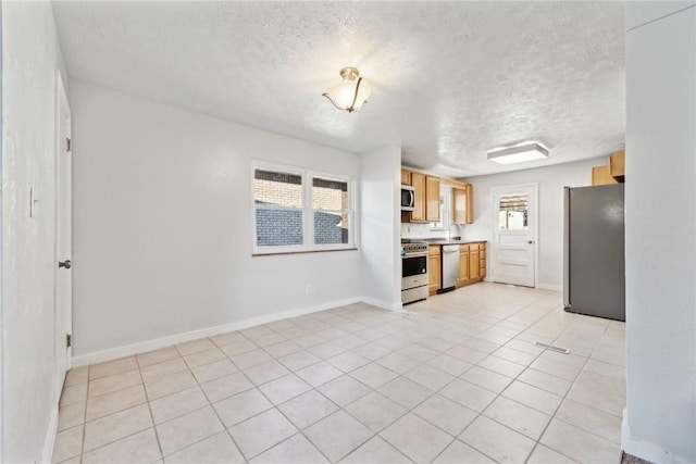 1805 Lincoln Way, White Oak, PA 15131 - kitchen with stainless steel appliances, a textured ceiling, baseboards, and light countertops