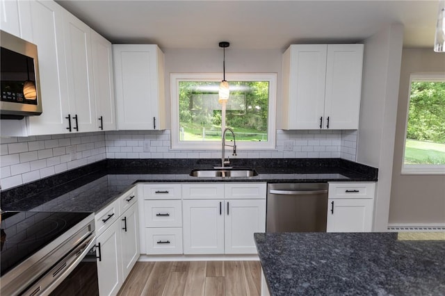 5 Albert St, South Union Twp, PA 15401 - kitchen featuring appliances with stainless steel finishes, dark stone counters, white cabinetry, pendant lighting, and light wood-style floors
