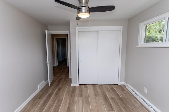 5 Albert St, South Union Twp, PA 15401 - unfurnished bedroom featuring baseboard heating, light wood finished floors, a closet, and a ceiling fan