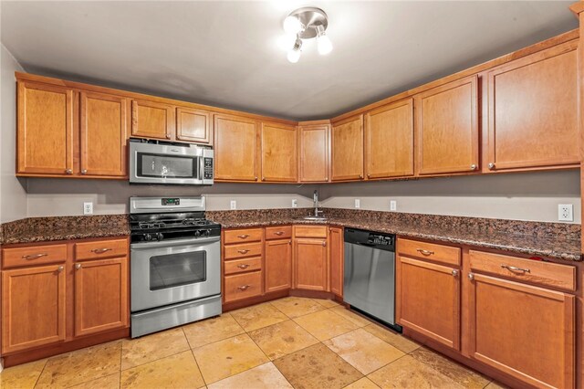 1816 Jane, South Side, PA 15203 - kitchen featuring appliances with stainless steel finishes, dark stone counters, brown cabinetry, and a sink