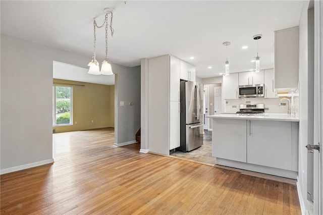 306 Tadmar Ave, Ross Twp, PA 15237 - kitchen featuring stainless steel appliances, baseboards, light wood-style flooring, a peninsula, and white cabinetry