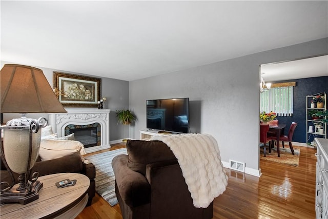 1137 Michael Dr, Baldwin Boro, PA 15227 - living room featuring wood finished floors, baseboards, a fireplace, and a chandelier