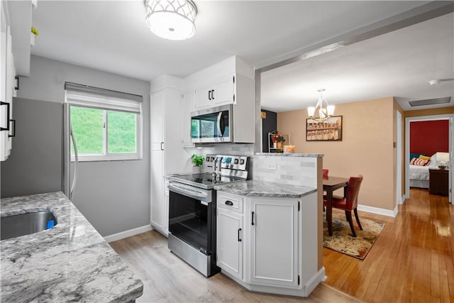 1137 Michael Dr, Baldwin Boro, PA 15227 - kitchen featuring stainless steel appliances, light wood-style flooring, white cabinets, and light stone counters
