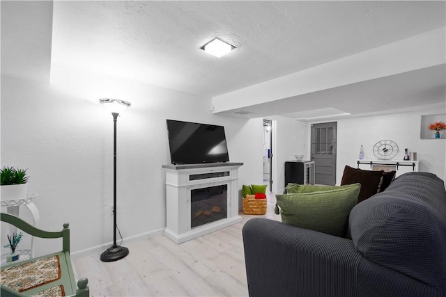 1137 Michael Dr, Baldwin Boro, PA 15227 - living area with wood finished floors, a glass covered fireplace, baseboards, and a textured ceiling