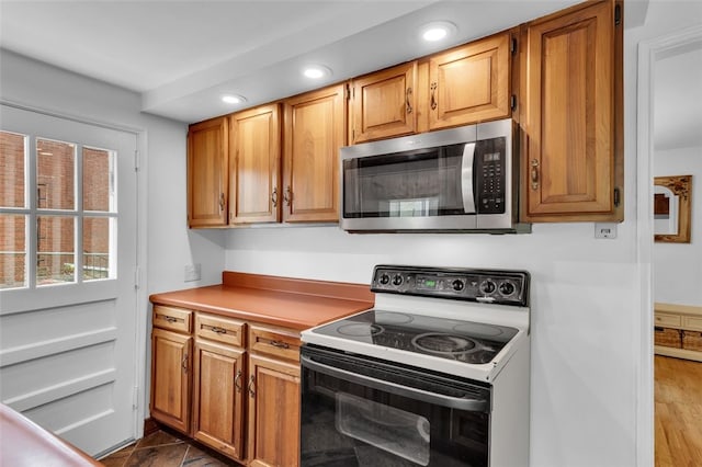 5352 Highgrove Rd, Whitehall, PA 15236 - kitchen with stainless steel microwave, electric range oven, recessed lighting, brown cabinetry, and light countertops