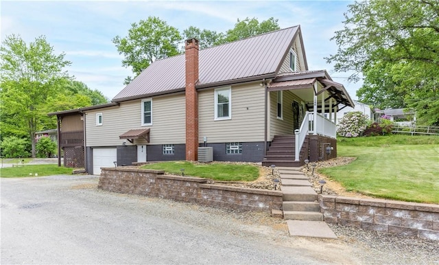 1248 Hyde Park Rd, Allegheny Twp Wml, PA 15656 - view of front facade featuring a chimney, dirt driveway, a front lawn, metal roof, and an attached garage