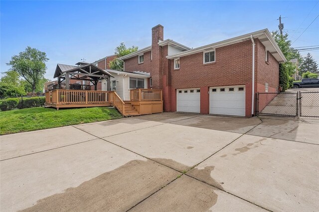 1426 Raven Dr, Pittsburgh, PA 15243 - rear view of property featuring concrete driveway, a wooden deck, an attached garage, a gate, and brick siding