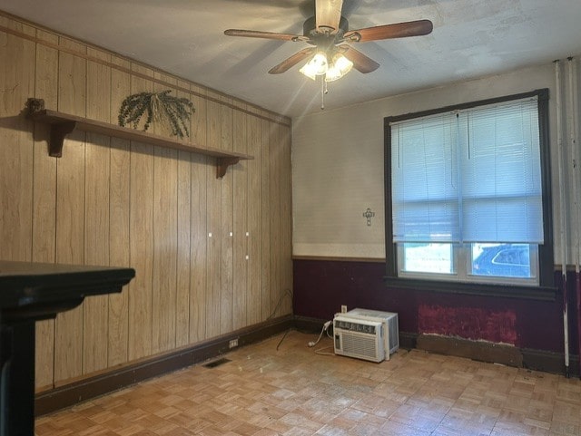 213 Indiana Ave, Avonmore, PA 15618 - empty room with wooden walls, ceiling fan, a wall unit AC, and baseboards