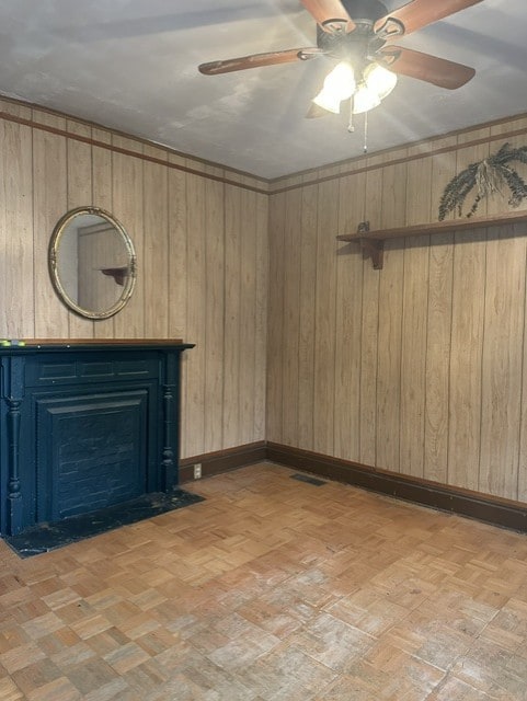 213 Indiana Ave, Avonmore, PA 15618 - spare room featuring a ceiling fan, wooden walls, and a fireplace