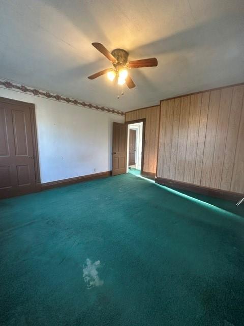 213 Indiana Ave, Avonmore, PA 15618 - unfurnished bedroom with baseboards, carpet, a ceiling fan, and wooden walls