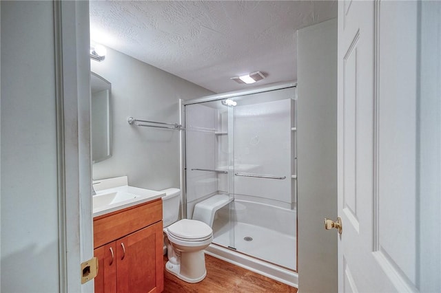 3318 Carriage Cir, Murrysville, PA 15632 - full bath featuring vanity, a stall shower, toilet, a textured ceiling, and wood finished floors