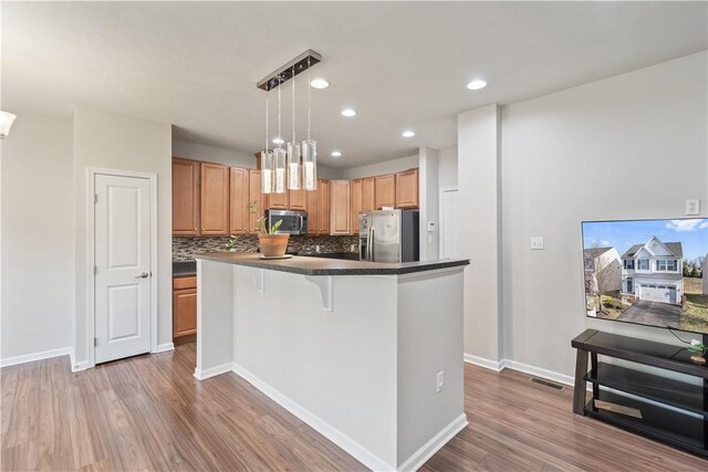 6202 Lenox Ln, South Fayette, PA 15057 - kitchen with appliances with stainless steel finishes, dark countertops, wood finished floors, backsplash, and recessed lighting