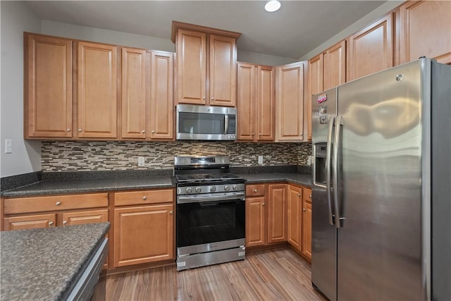 6202 Lenox Ln, South Fayette, PA 15057 - kitchen featuring stainless steel appliances, dark countertops, light wood-style flooring, decorative backsplash, and recessed lighting