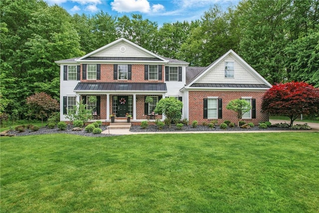 2104 Pierce Bluffs Dr, Hermitage, PA 16148 - view of front of house featuring a standing seam roof, covered porch, a front yard, brick siding, and metal roof