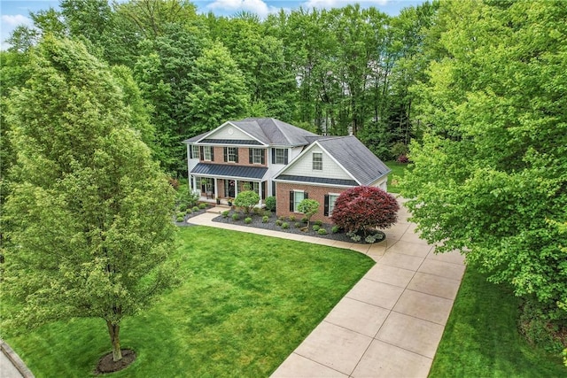 2104 Pierce Bluffs Dr, Hermitage, PA 16148 - view of front facade with concrete driveway, a front lawn, a standing seam roof, covered porch, and a forest view