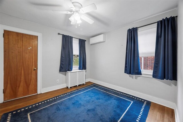 446 S Dallas Ave, Point Breeze, PA 15208 - unfurnished room featuring a wall mounted air conditioner, wood finished floors, baseboards, radiator heating unit, and a ceiling fan