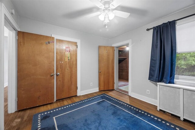 446 S Dallas Ave, Point Breeze, PA 15208 - unfurnished bedroom with wood finished floors, baseboards, a ceiling fan, and radiator heating unit