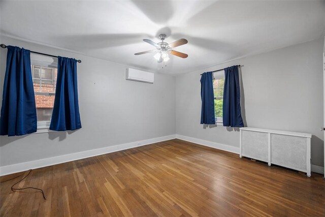 446 S Dallas Ave, Point Breeze, PA 15208 - spare room featuring radiator, a wall unit AC, baseboards, ceiling fan, and wood finished floors