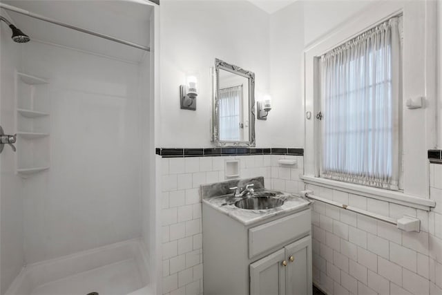 446 S Dallas Ave, Point Breeze, PA 15208 - bathroom featuring tile walls, a shower, vanity, and wainscoting