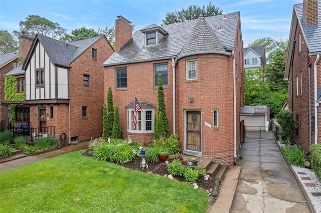 446 S Dallas Ave, Point Breeze, PA 15208 - view of front of home featuring a high end roof, brick siding, a front yard, and a chimney