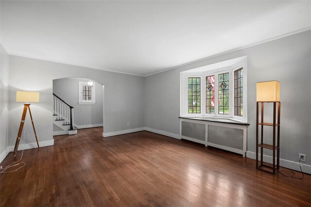 446 S Dallas Ave, Point Breeze, PA 15208 - spare room featuring crown molding, stairway, wood finished floors, arched walkways, and baseboards
