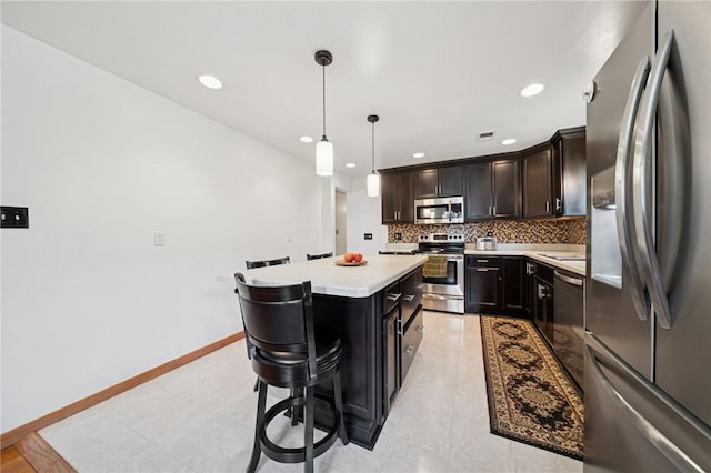 954 Illinois Ave, Braddock Hills, PA 15221 - kitchen featuring appliances with stainless steel finishes, tasteful backsplash, a breakfast bar area, light countertops, and a center island