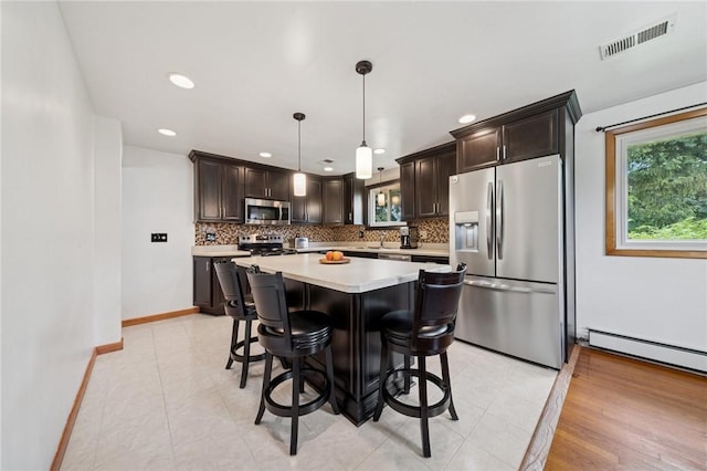 954 Illinois Ave, Braddock Hills, PA 15221 - kitchen with appliances with stainless steel finishes, tasteful backsplash, light countertops, dark brown cabinets, and a center island
