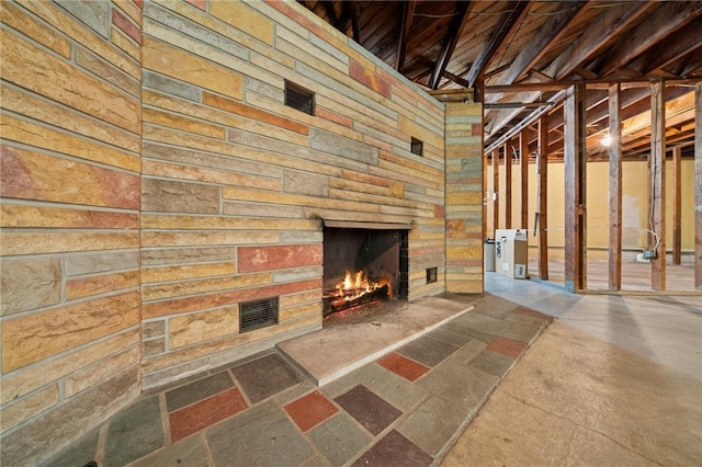 954 Illinois Ave, Braddock Hills, PA 15221 - unfurnished living room featuring stone tile flooring, wood walls, and an outdoor stone fireplace