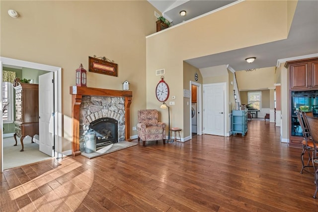 361 Patriot Ln, Economy, PA 15042 - living room featuring a stone fireplace, dark wood-type flooring, a towering ceiling, and baseboards