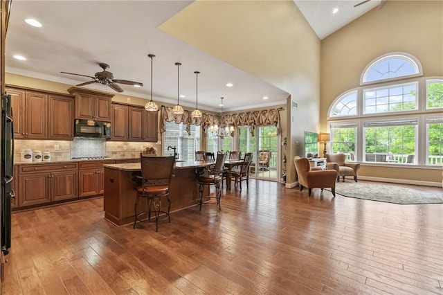 361 Patriot Ln, Economy, PA 15042 - kitchen featuring black microwave, a ceiling fan, brown cabinets, a kitchen bar, and a kitchen island with sink