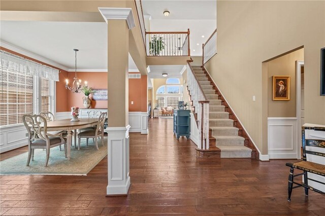 361 Patriot Ln, Economy, PA 15042 - dining space with a chandelier, a decorative wall, stairs, a wainscoted wall, and dark wood-style flooring