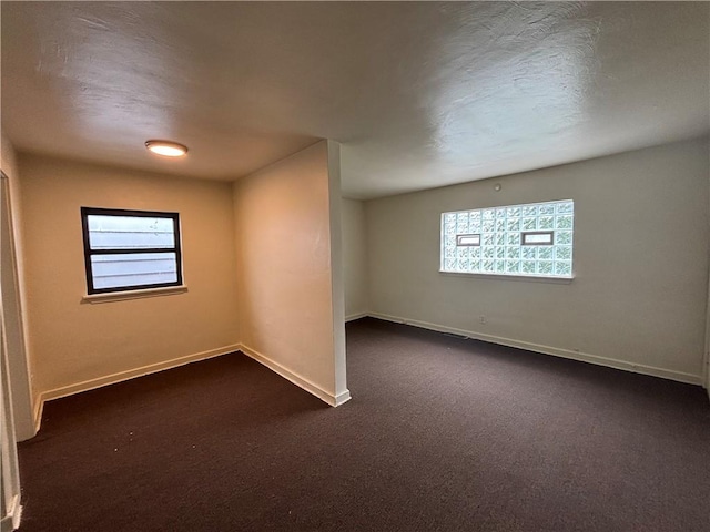 7707-7708-7710 Forest Way, Homewood-Brushton, PA 15208 - empty room featuring healthy amount of natural light, dark colored carpet, and baseboards