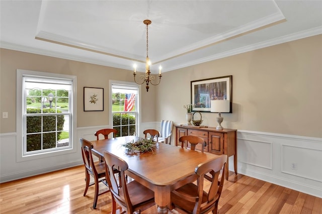 104 Southridge Dr, Cranberry Twp, PA 16066 - dining area featuring a tray ceiling, light wood-style flooring, a chandelier, wainscoting, and ornamental molding