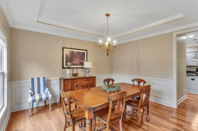 104 Southridge Dr, Cranberry Twp, PA 16066 - dining room with a tray ceiling, light wood finished floors, a chandelier, wainscoting, and ornamental molding