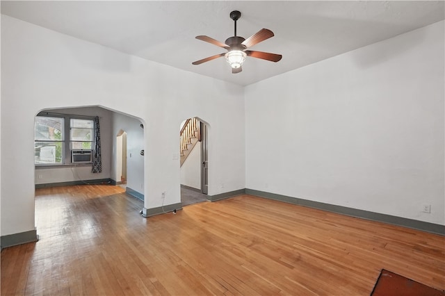 342 E 11th Ave, Homestead, PA 15120 - unfurnished room with arched walkways, hardwood / wood-style floors, a ceiling fan, baseboards, and stairway