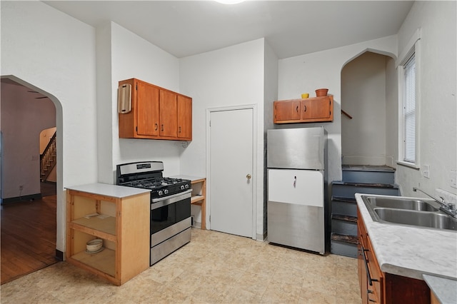 342 E 11th Ave, Homestead, PA 15120 - kitchen featuring stainless steel appliances, arched walkways, a sink, and light countertops