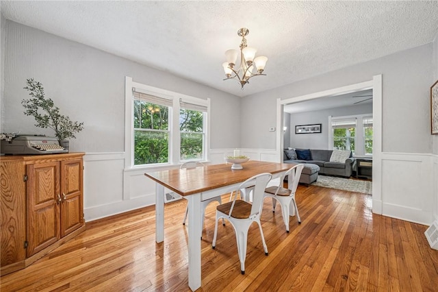 510 Central Ave E, Washington Boro, PA 15301 - dining area featuring a chandelier, light wood finished floors, a wainscoted wall, a textured ceiling, and a decorative wall