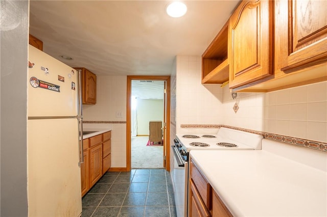 302 Shutt Rd, Hempfield Twp Wml, PA 15601 - kitchen featuring white appliances, light countertops, brown cabinets, dark tile patterned floors, and decorative backsplash