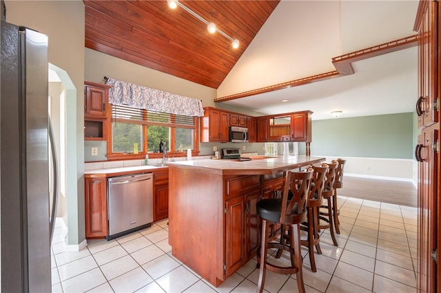 302 Shutt Rd, Hempfield Twp Wml, PA 15601 - kitchen featuring appliances with stainless steel finishes, wood ceiling, light tile patterned flooring, a breakfast bar area, and a kitchen island