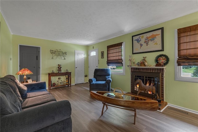 125 Spruce St, Brighton Twp, PA 15009 - living area featuring wood finished floors, a brick fireplace, a textured ceiling, and baseboards