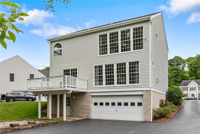 117 Trailside Ct, North Fayette, PA 15108 - back of property featuring asphalt driveway, an attached garage, brick siding, a wooden deck, and a yard