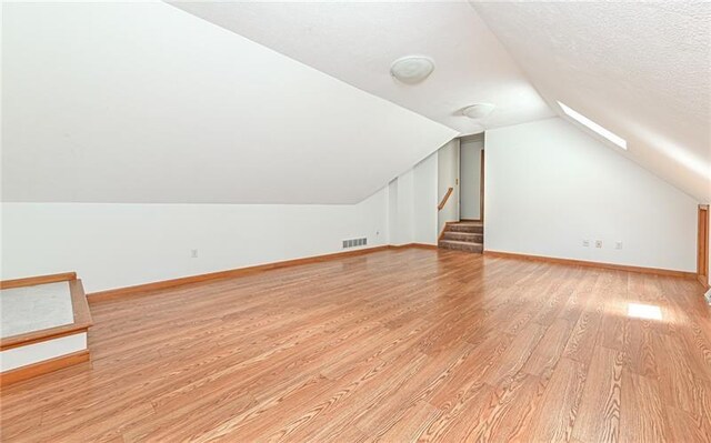103 Mcdonnell Ln, Middlesex Twp, PA 16002 - additional living space with light wood finished floors, vaulted ceiling, baseboards, and stairway